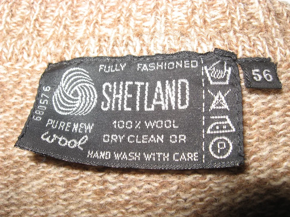 A sewn-in care label on a wool jumper showing hand-wash, do-not-bleach, iron and professional-cleaning symbols (example label, not a Mountain Explora garment)