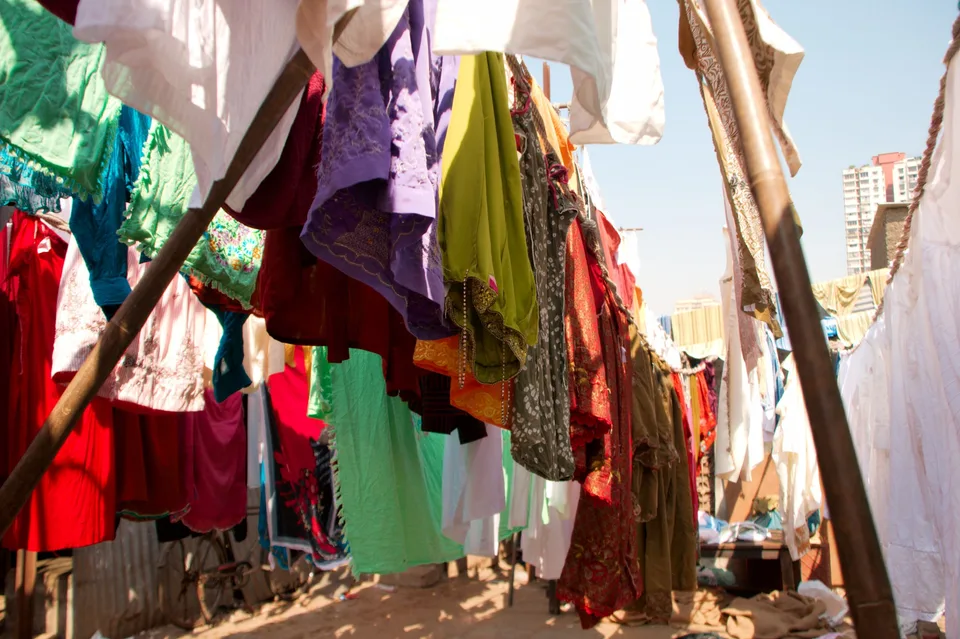 Brightly coloured clothes hanging on lines to dry outdoors